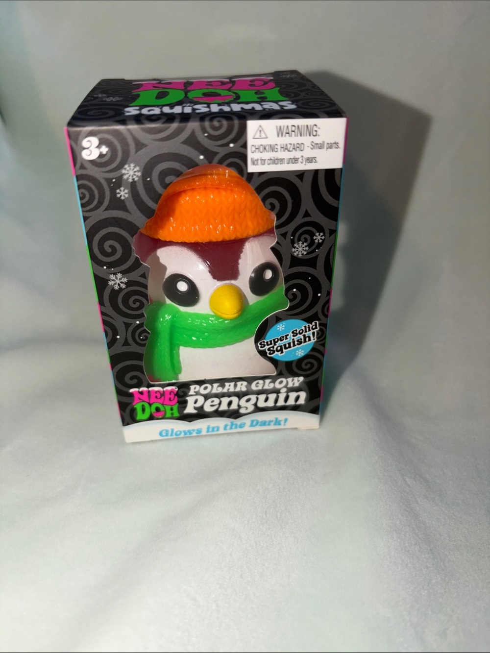 NeeDoh Polar Glow Penguin - orange hat , green scarf